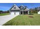 Charming two-story home boasts a manicured lawn, two-car garage, and stylish architectural details at 76 Abingdon Farms Dr, Selma, NC 27576