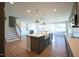 Open-concept kitchen boasts a large island, stainless steel appliances, and stylish pendant lighting at 76 Abingdon Farms Dr, Selma, NC 27576