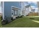 View of the backyard featuring a well-maintained lawn, houses, and a central air conditioning unit at 1660 Piney Falls Dr, Wendell, NC 27591
