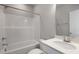 Clean bathroom featuring a shower-tub combo, quartz counters, and modern fixtures at 1660 Piney Falls Dr, Wendell, NC 27591