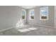 A bedroom with three windows, neutral colored walls, and carpet at 1660 Piney Falls Dr, Wendell, NC 27591