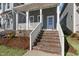 Inviting front porch of a home featuring brick stairs, white railings, and overhead lighting at 1660 Piney Falls Dr, Wendell, NC 27591