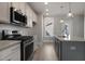 Modern kitchen featuring stainless steel appliances, gray cabinets, and a quartz countertop island at 1660 Piney Falls Dr, Wendell, NC 27591