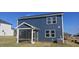 Exterior back view showcases a two-story blue home with a screened-in porch and spacious yard at 19 Longdale Dr, Graham, NC 27253