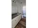 Modern bathroom featuring double sink vanity with elegant wood-look floors and a shower/tub combo at 19 Longdale Dr, Graham, NC 27253