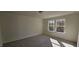 Bright bedroom with neutral carpet and two windows offering lots of natural light at 19 Longdale Dr, Graham, NC 27253