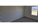A cozy bedroom with neutral carpet and paint, and a window for natural light at 19 Longdale Dr, Graham, NC 27253