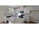Well-lit kitchen features white cabinetry, stainless steel appliances, stone countertops, and stylish backsplash at 19 Longdale Dr, Graham, NC 27253