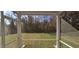 Relaxing screened porch featuring a view to a wooded backyard, ideal for enjoying the outdoors comfortably at 19 Longdale Dr, Graham, NC 27253