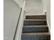 Carpeted staircase with white railings at 7220 Shellburne Dr, Raleigh, NC 27612