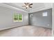 Spacious bedroom with a trey ceiling, ceiling fan, wood-look flooring, and natural light at 167 Thistle Ct, Sanford, NC 27332