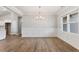 Dining room featuring modern chandelier, decorative wall trim, and wood-look flooring at 167 Thistle Ct, Sanford, NC 27332