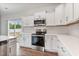 Bright kitchen with white cabinets, stainless appliances, quartz countertops, and modern backsplash at 167 Thistle Ct, Sanford, NC 27332