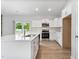 Modern kitchen with island, white cabinets, stainless steel appliances, and wood-look floors at 167 Thistle Ct, Sanford, NC 27332