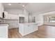 Open-concept kitchen with white cabinets, island, and view into adjacent living area at 167 Thistle Ct, Sanford, NC 27332