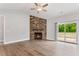 Spacious living room with stone fireplace, ceiling fan, and sliding glass door to patio at 167 Thistle Ct, Sanford, NC 27332