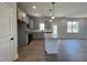 Open kitchen area with gray cabinets, an island with granite countertops, and modern appliances at 17 S Mistflower St, Clayton, NC 27520