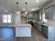 Well-lit kitchen with gray cabinets, stainless steel appliances, granite countertops, and an island at 17 S Mistflower St, Clayton, NC 27520