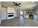 Open-concept living area features a fireplace, built-in shelving, a kitchen island and ceiling fan at 17 S Mistflower St, Clayton, NC 27520