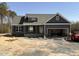 New home with gray siding, stone accents, covered porch, and an attached two-car garage at 182 Wilderness Trl, Smithfield, NC 27577