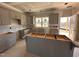 Bright kitchen featuring shaker style gray cabinets, kitchen island, and an exterior access door at 182 Wilderness Trl, Smithfield, NC 27577