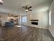 Open-concept living room with hardwood floors, fireplace feature wall and kitchen in background at 20 S Mistflower St, Clayton, NC 27520