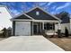 Charming single-story home featuring a one-car garage and covered front porch with stone accents at 23 S Mistflower St, Clayton, NC 27520