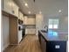 Open-concept kitchen with a large island, stainless steel appliances, and white shaker cabinets at 23 S Mistflower St, Clayton, NC 27520