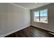 Neutral bedroom featuring a large window bringing in natural light and wood-look flooring at 232 Bluejay St, Clayton, NC 27520