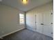 Bright bedroom with a large window, neutral walls, carpet, and closet at 238 Bluejay St, Clayton, NC 27520