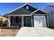 Charming new construction home with a blue exterior, covered porch, and a convenient attached garage at 238 Bluejay St, Clayton, NC 27520