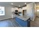 Bright kitchen features white cabinetry, granite counters, stainless appliances, and a stylish blue island at 238 Bluejay St, Clayton, NC 27520