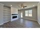 Cozy living room featuring a modern fireplace, custom built-in shelves, and a bright window at 238 Bluejay St, Clayton, NC 27520