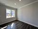 Well-lit empty room with dark wood floors, white trim, and a large window showcasing the exterior at 24 S Mistflower St, Clayton, NC 27520