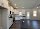 Bright kitchen featuring white cabinetry, granite counters, stainless steel appliances, and a gray island at 24 S Mistflower St, Clayton, NC 27520