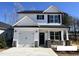 Charming two-story home with a white exterior, black accents, and a well-manicured front yard at 35 S Mistflower St, Clayton, NC 27520