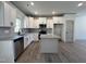 Modern kitchen featuring white cabinetry, stainless steel appliances, granite countertops, and a center island at 35 S Mistflower St, Clayton, NC 27520