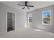 Bright bedroom with large windows, plush carpeting, and a modern ceiling fan, perfect for relaxation at 65 Cherry Bark Dr, Youngsville, NC 27596
