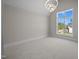 Bright, carpeted bedroom features large windows and a modern chandelier at 65 Cherry Bark Dr, Youngsville, NC 27596