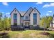 Striking exterior showcasing a modern two-story home with black-framed windows and lush green lawn at 65 Cherry Bark Dr, Youngsville, NC 27596