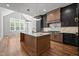 Open kitchen area featuring an island, gray cabinets, marble counters, hardwood floors and stylish lighting fixtures at 65 Cherry Bark Dr, Youngsville, NC 27596