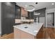 A modern kitchen featuring custom gray cabinets, an island with a marble countertop and sleek pendant lighting at 65 Cherry Bark Dr, Youngsville, NC 27596