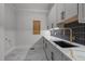Bright laundry room with gray cabinets, gold hardware and faucet, white countertops, and tiled backsplash at 65 Cherry Bark Dr, Youngsville, NC 27596