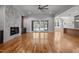Spacious open-plan living area with hardwood floors, fireplace, built-ins, a fan and access to outdoor spaces at 65 Cherry Bark Dr, Youngsville, NC 27596