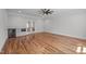 Spacious living room featuring hardwood floors, modern ceiling fan, and custom-built bar area with a wine fridge at 65 Cherry Bark Dr, Youngsville, NC 27596