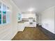 Eat-in kitchen features white cabinetry, updated appliances, neutral countertops, and two different flooring types at 225 W Orange St, Hillsborough, NC 27278