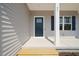 Inviting covered front porch with blue front door and decorative columns at 63 Falls River Ct, Broadway, NC 27505
