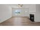 Contemporary living room with fireplace, large window, and durable hardwood-style floors at 63 Falls River Ct, Broadway, NC 27505