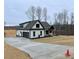 Modern farmhouse showcasing a spacious driveway, attached garage, and well-maintained landscaping at 2829 Faucette Ln, Burlington, NC 27217