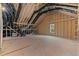 An unfinished attic area with exposed wood frame, vents, insulation, and a small window at 100 Carol Cir, Louisburg, NC 27549